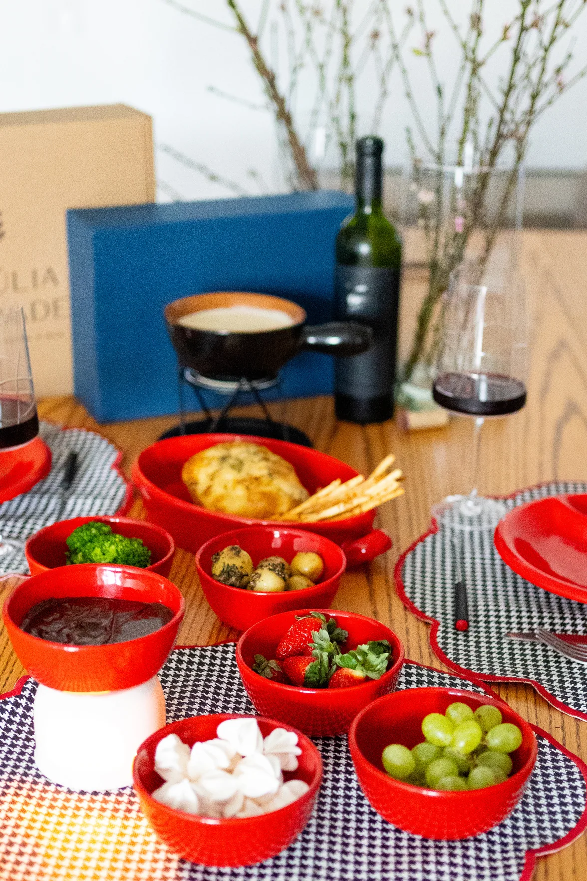Mesa montada com a panela de fondue de queijo e as tigelas de acompanhamento