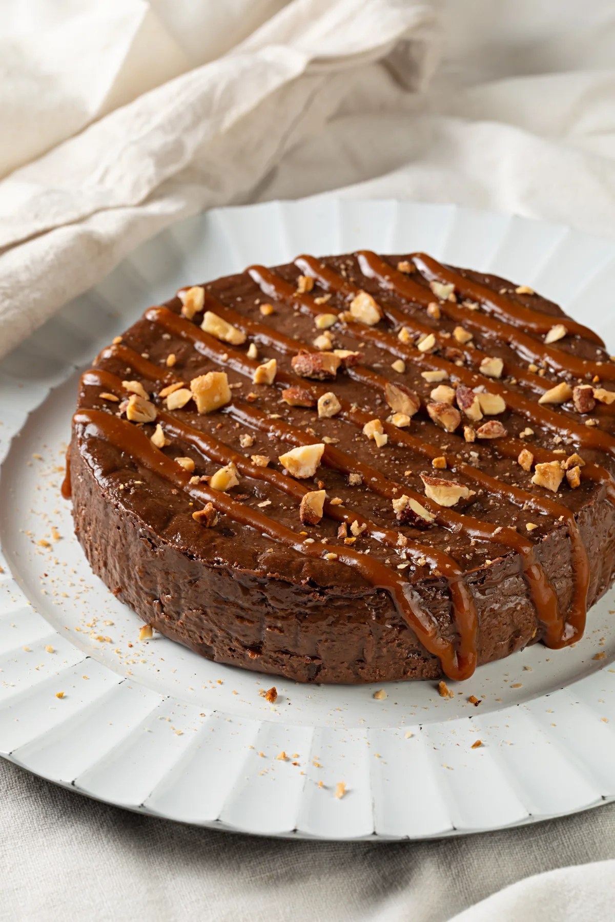 Tarta mousse de chocolate com caramelo salgado desenhado por cima e nuts caramelizadas