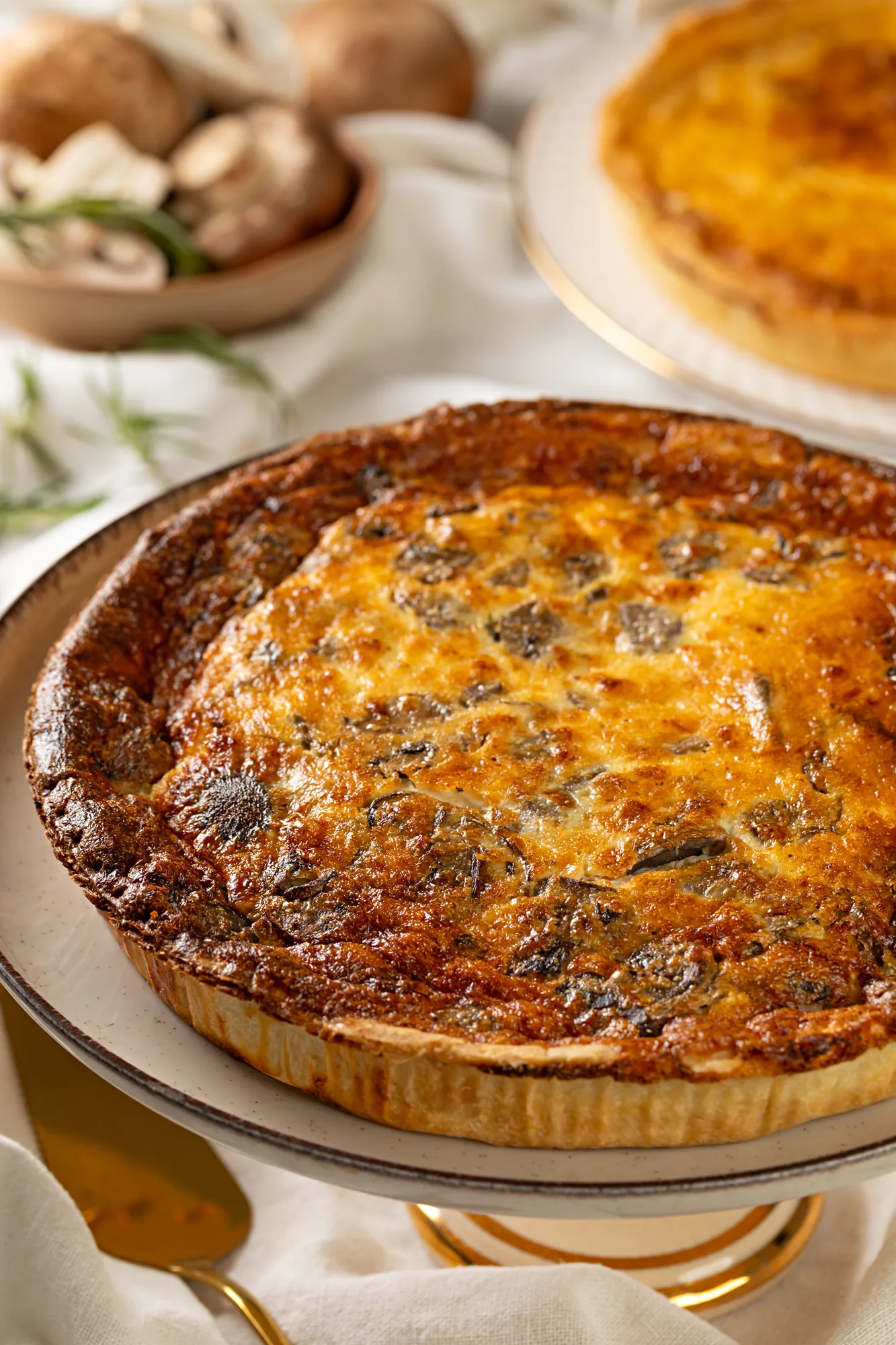 Quiche inteira assada, com a superfície dourada e a borda de massa canelada