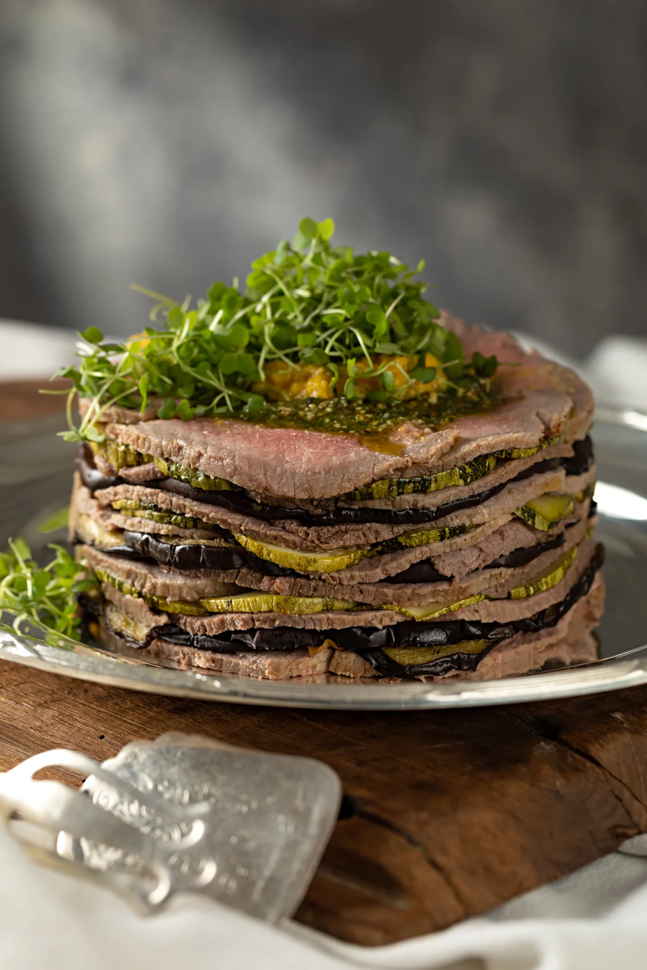 Torre de fatias de roastbeef intercaladas, finalizada com folhas verdes